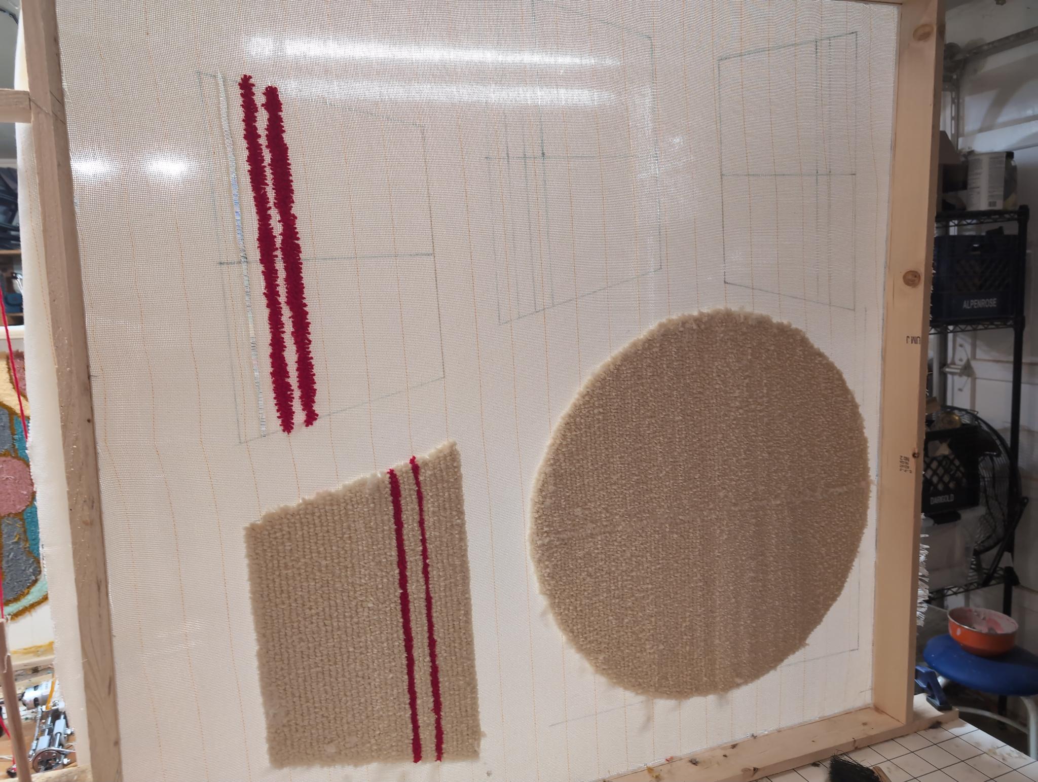 Tufting in progress on the frame: pencil layout lines drawn on the cloth, the red rim stripes tufted first, a partial cream bowl panel and the round base