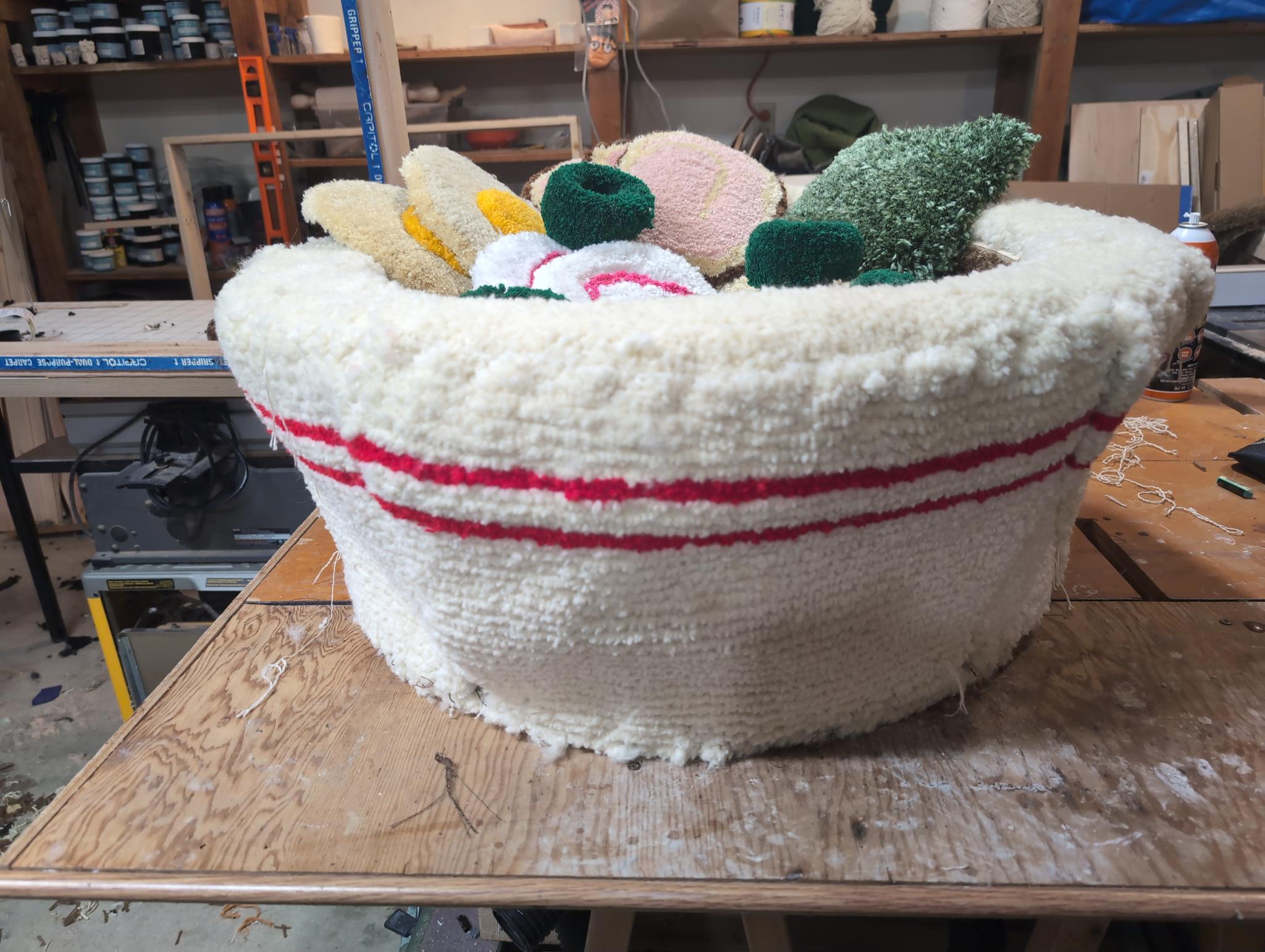 The assembled bowl from the side, cream tufted exterior with the red rim band, ingredients piled inside
